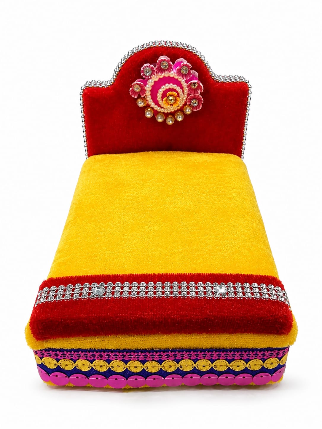 A vibrant, handcrafted decorative cushion or small bench featuring a bright yellow velvet body, a red velvet headrest, and intricate embellishments including silver rhinestone borders, a pink and gold floral motif on the headrest, and yellow sequins along the base.